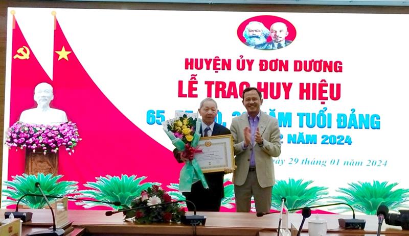 Bí thư Huyện ủy Đơn Dương Trương Văn Tùng trao Huy hiệu 65 năm tuổi Đảng cho  đảng viên Lê Văn Nhĩ